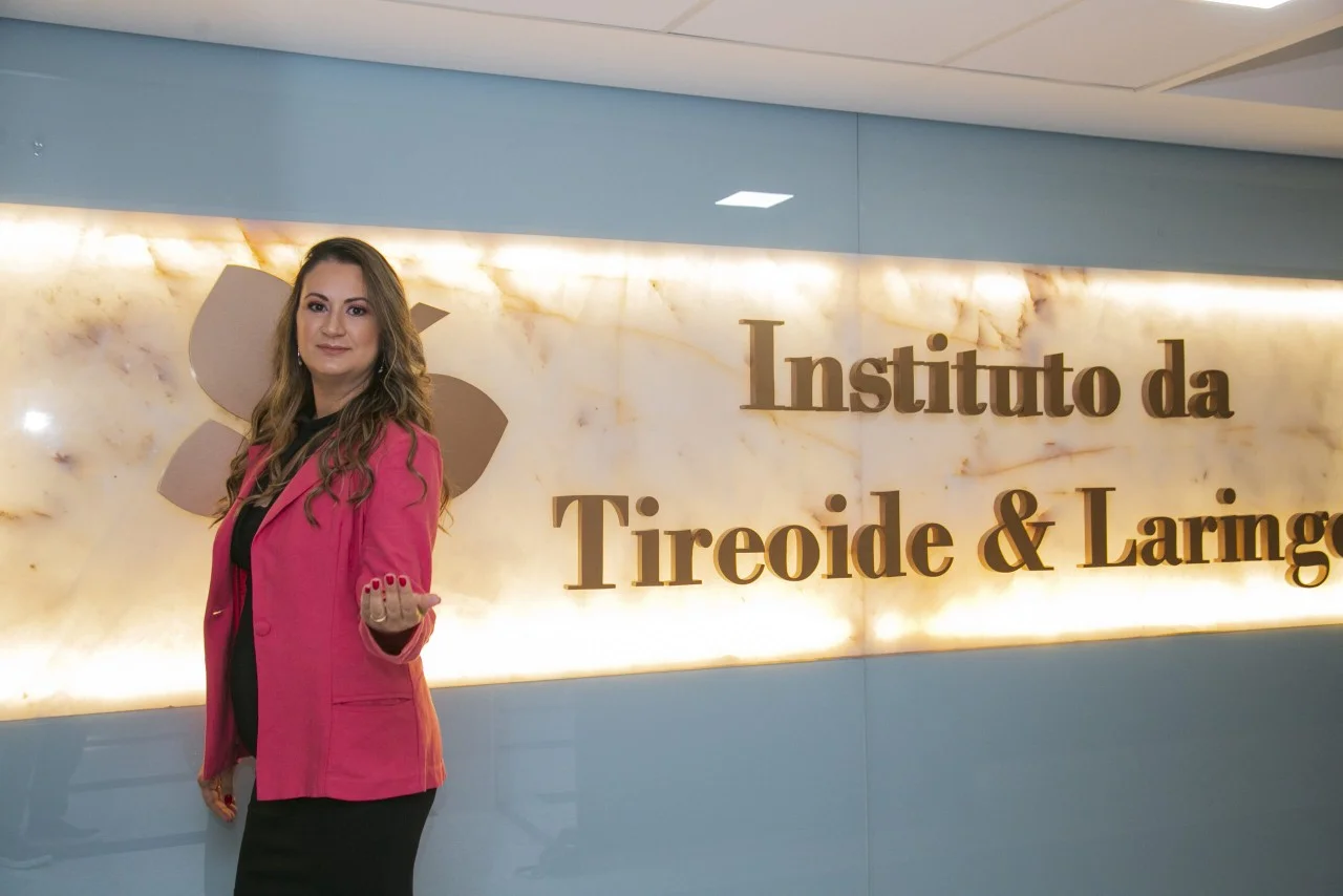 Aline Marques, gerente administrativa do ITL, em frente ao painel do Instituto, na recepção da clínica.