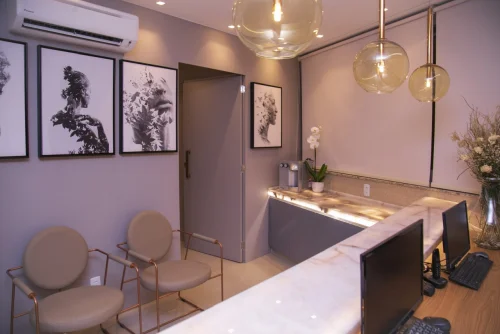 Sala de espera do ITL, com poltronas e quadros na parede.